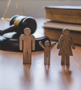 Figuras de madera de una familia junto a un mazo de juez